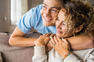 Portrait of happy friends sitting on sofa
