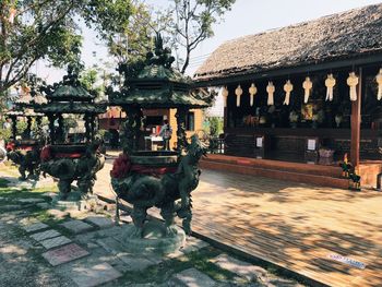 Statue by temple against sky