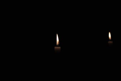 Close-up of lit candle in dark room