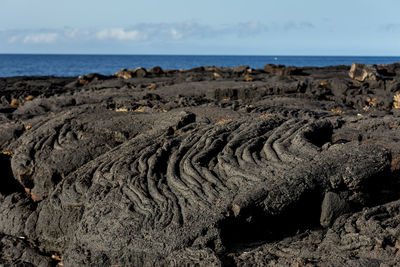 Scenic view of volcanics rocks on beach against sky