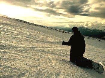 Scenic view of snow covered mountains against cloudy sky