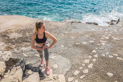 Woman running training on sea coastline under sunlight in sunny summer day. sport, run, health.