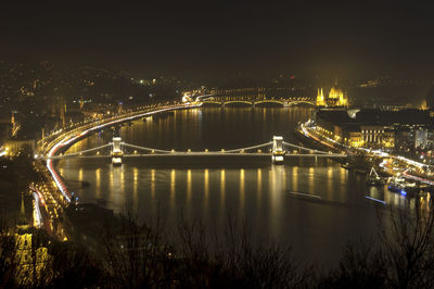 Bridge over river in city at night
