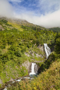 Scenic view of waterfall against sky