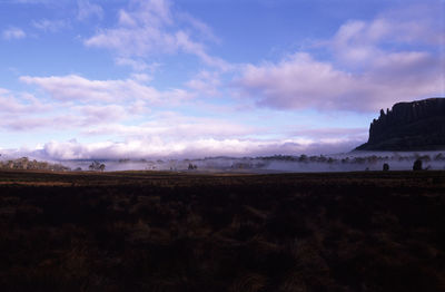 Scenic view of mountains against cloudy sky