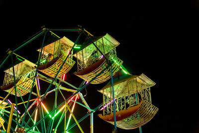 Close-up of illuminated lighting equipment against black background