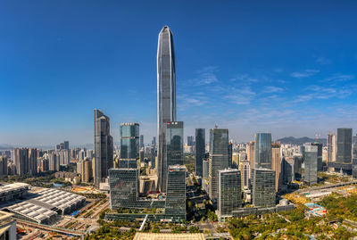 Modern buildings in city against blue sky