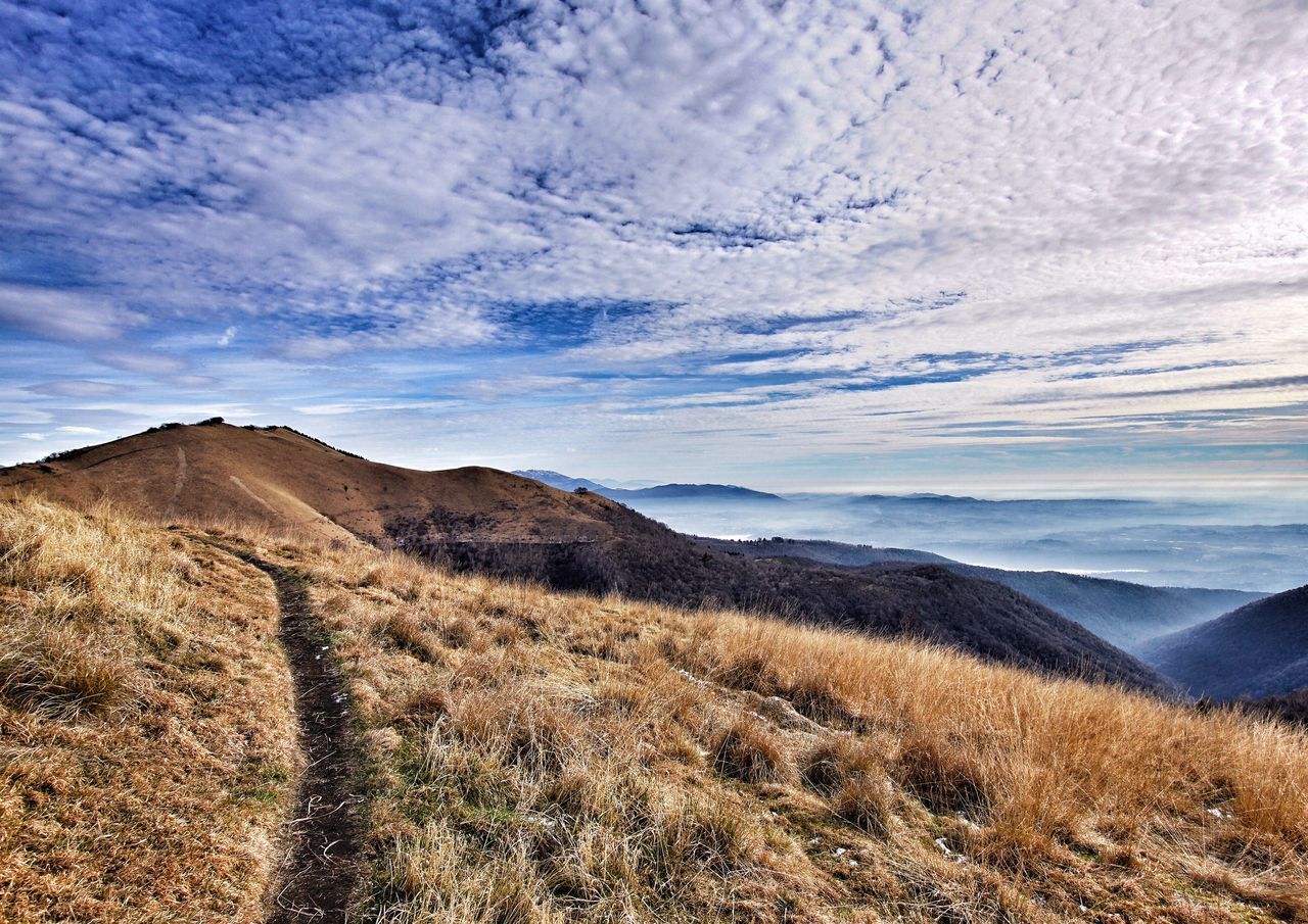 mountain, tranquil scene, scenics, landscape, cloud - sky, tranquility, sky, beauty in nature, non-urban scene, travel destinations, mountain range, nature, remote, cloud, tourism, physical geography, cloudscape, cloudy, geology, day, blue, outdoors, arid climate, solitude, mountain peak, majestic, no people, extreme terrain, natural landmark