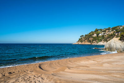 Scenic view of beach against blue sky