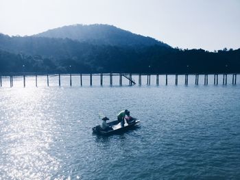Man on boat in lake against sky