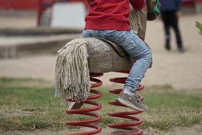 Low section of boy sitting on rocking horse