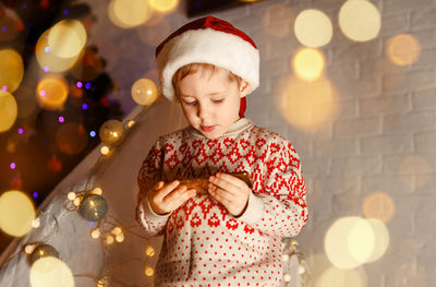 Full length of boy standing in illuminated christmas lights