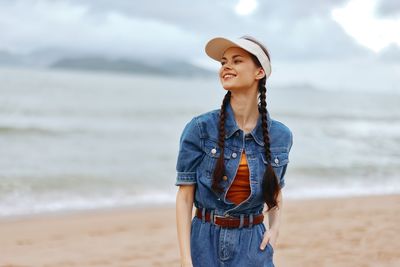 Portrait of young woman standing at beach