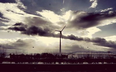 Wind turbine against cloudy sky