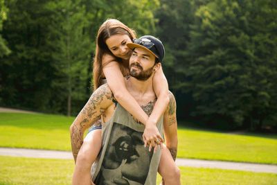 Young couple standing against plants