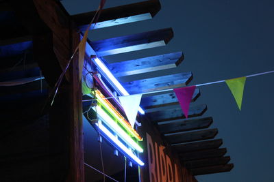 Low angle view of illuminated lighting equipment against sky at night