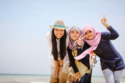 Portrait of female friends standing at beach