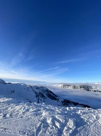 Scenic view of snowcapped mountains against blue sky