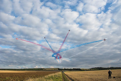 Airplane flying over landscape against sky