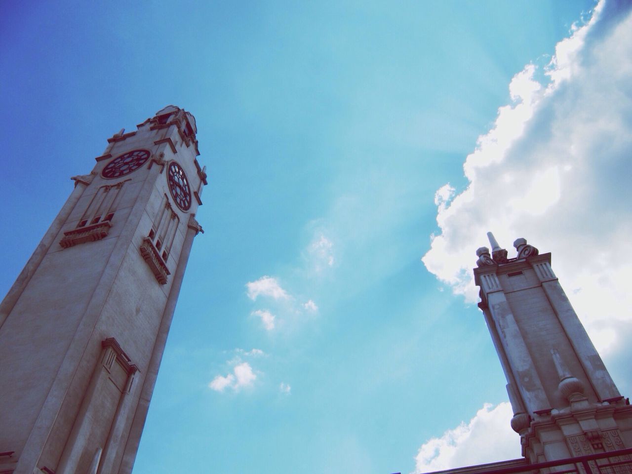 low angle view, architecture, built structure, building exterior, sky, tower, tall - high, history, famous place, travel destinations, blue, cloud - sky, cloud, city, international landmark, travel, tourism, capital cities, outdoors, no people