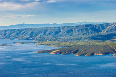 Scenic view of sea and mountains against sky