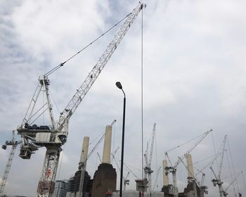 Low angle view of cranes against sky