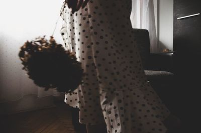 Rear view of woman standing at home