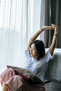 Woman sitting on bed at home