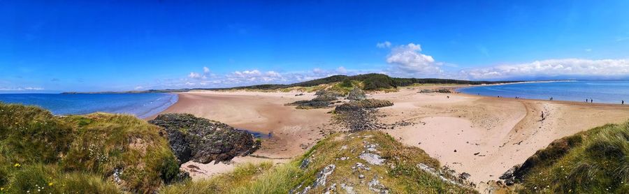 Scenic view of beach against blue sky