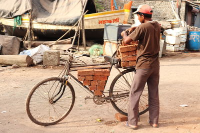 Rear view of man riding bicycles on street