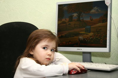 Close-up of serious girl playing game on computer