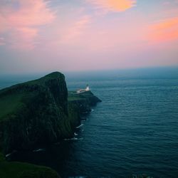 Scenic view of rock formation and sea against sky during sunset