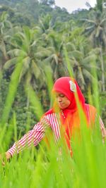 Woman with red umbrella on field