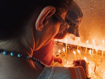 Rear view of mother with child lighting candles in church