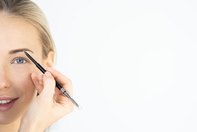 Portrait of woman making face against white background