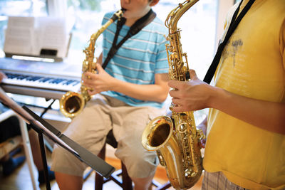 Boys practicing saxophones at home