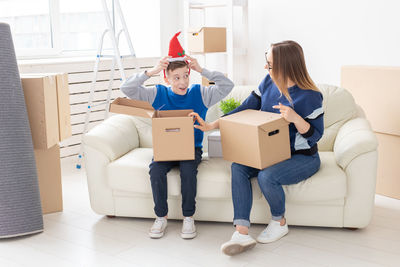 Woman sitting in box at home