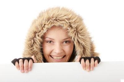 Portrait of smiling young woman against white background