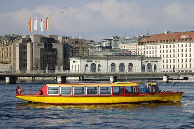 Boat in river against buildings in city