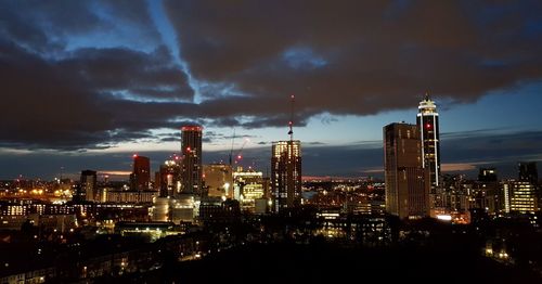 Illuminated cityscape against sky at night