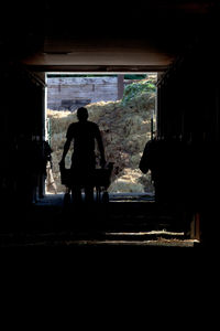 Rear view of silhouette man standing in tunnel