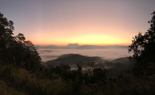 Scenic view of silhouette mountains against orange sky