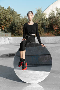 Portrait of young woman with mirror on skateboard park