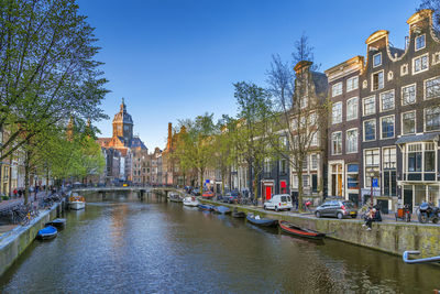 View of canal with basilica of st. nicholas, amsterdam, netherlands