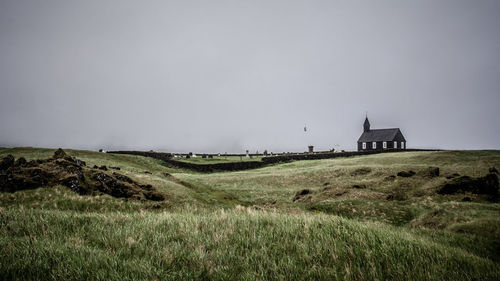 Scenic view of grassy field against sky