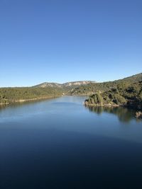 Scenic view of lake against clear blue sky