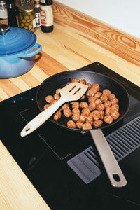 High angle view of meatballs in pan over ceramic stove top at home