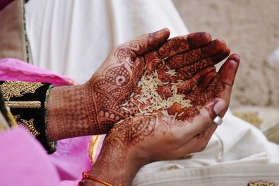 Midsection of woman holding rice in palm of hands
