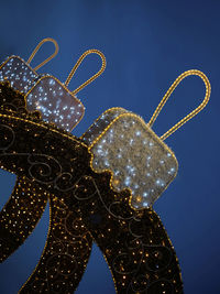 Low angle view of illuminated christmas lights against sky