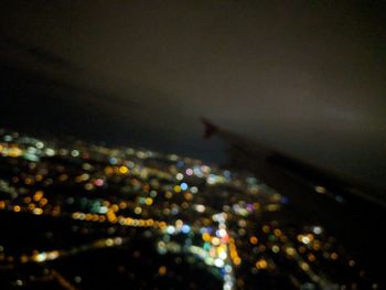 Aerial view of illuminated cityscape against sky at night